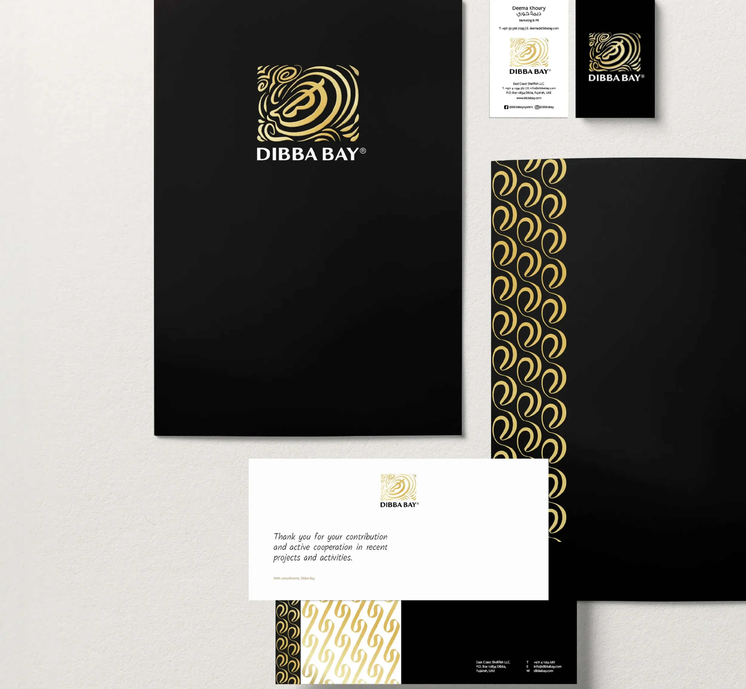 Dibba Bay Oysters premium black and gold stationery set including folder, cards, and packaging, designed by Skyne branding agency