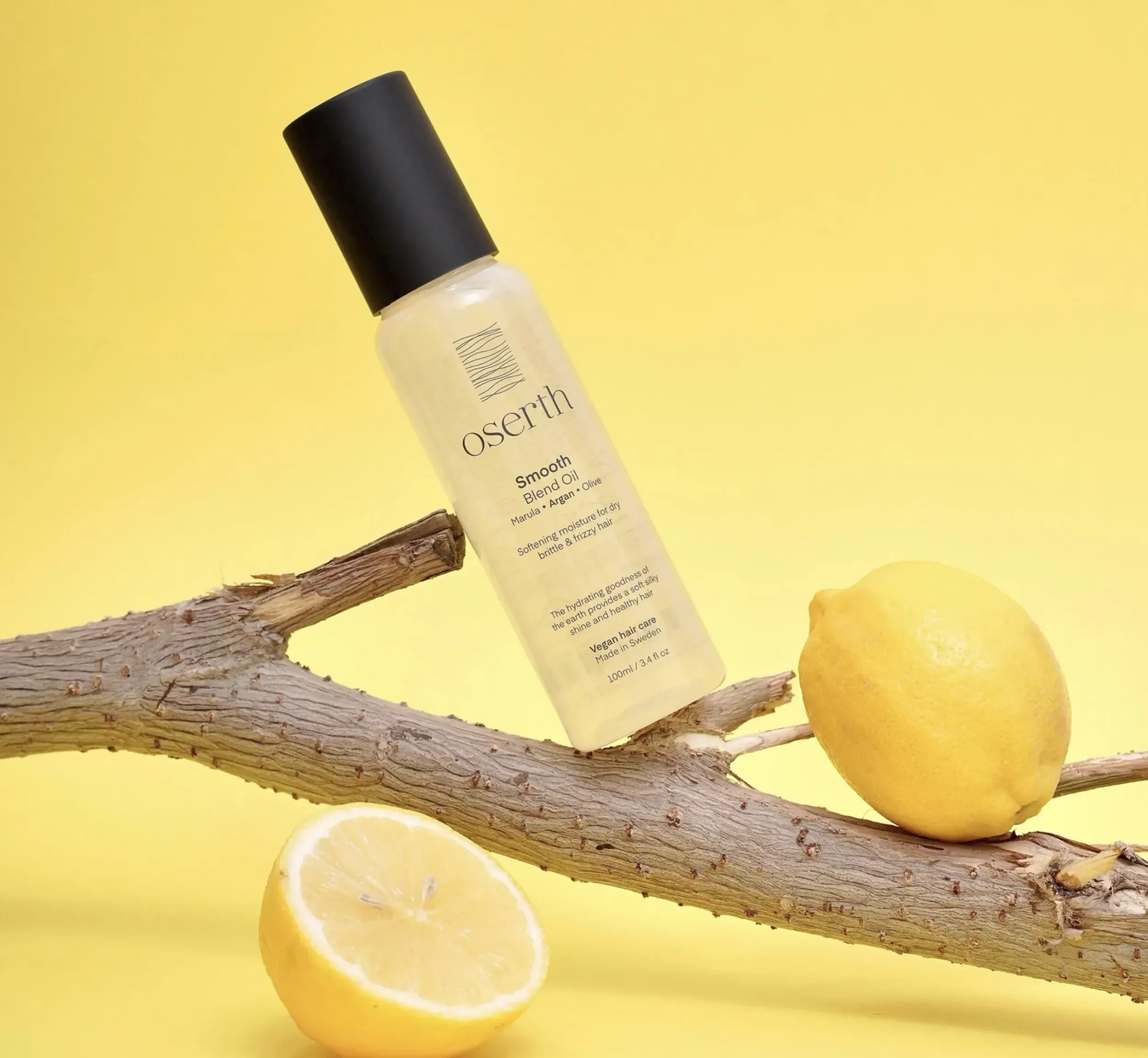 Oserth Smooth Blend Oil bottle on a tree branch with lemons, highlighting natural ingredients and refreshing qualities, and effective packaging design by Skyne, a creative agency specializing in packaging design.