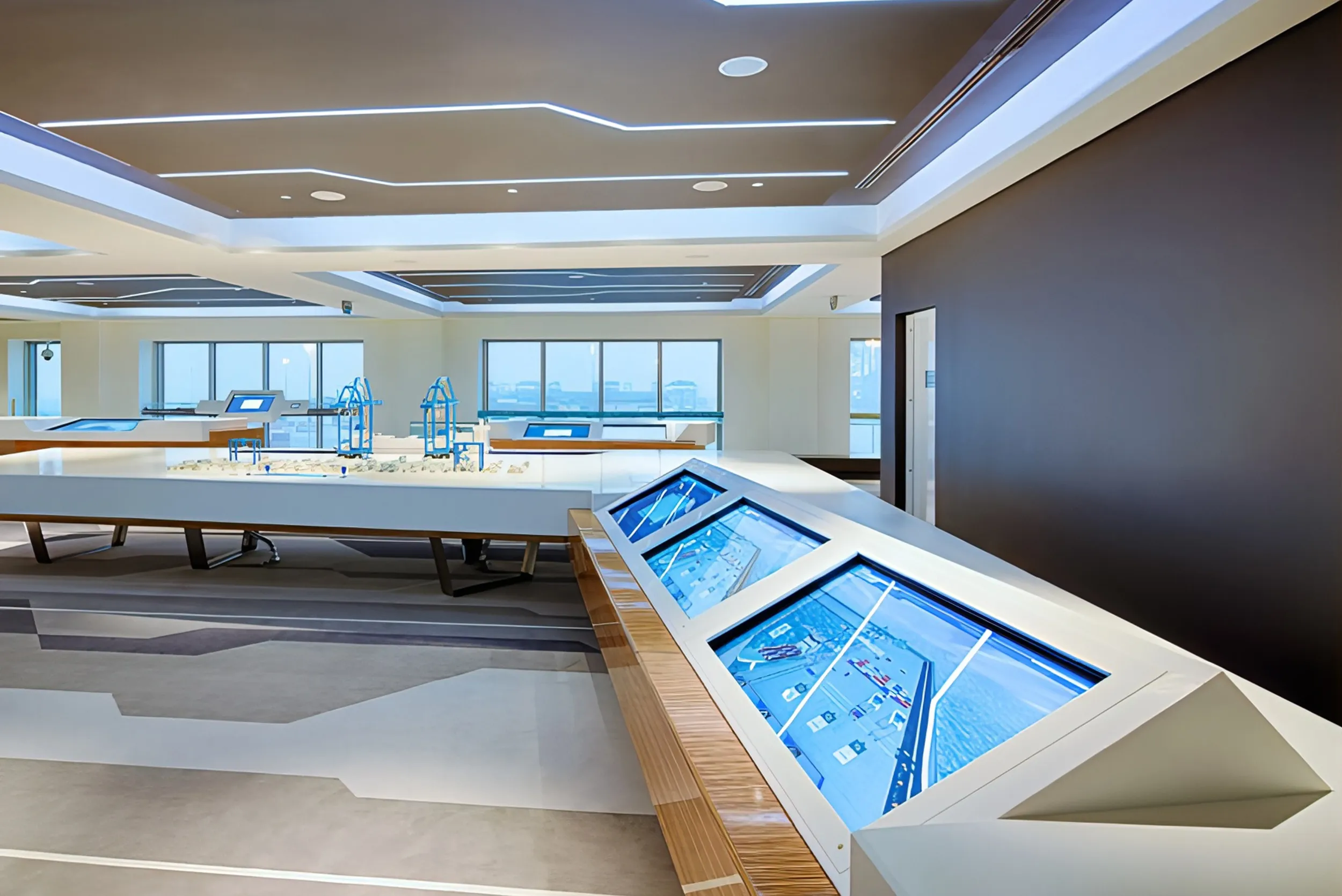 Modern interior of Abu Dhabi Ports visitor center with geometric patterns, interactive displays, and large windows. Skyne designs engaging visitor experiences and interior branding for corporate clients.