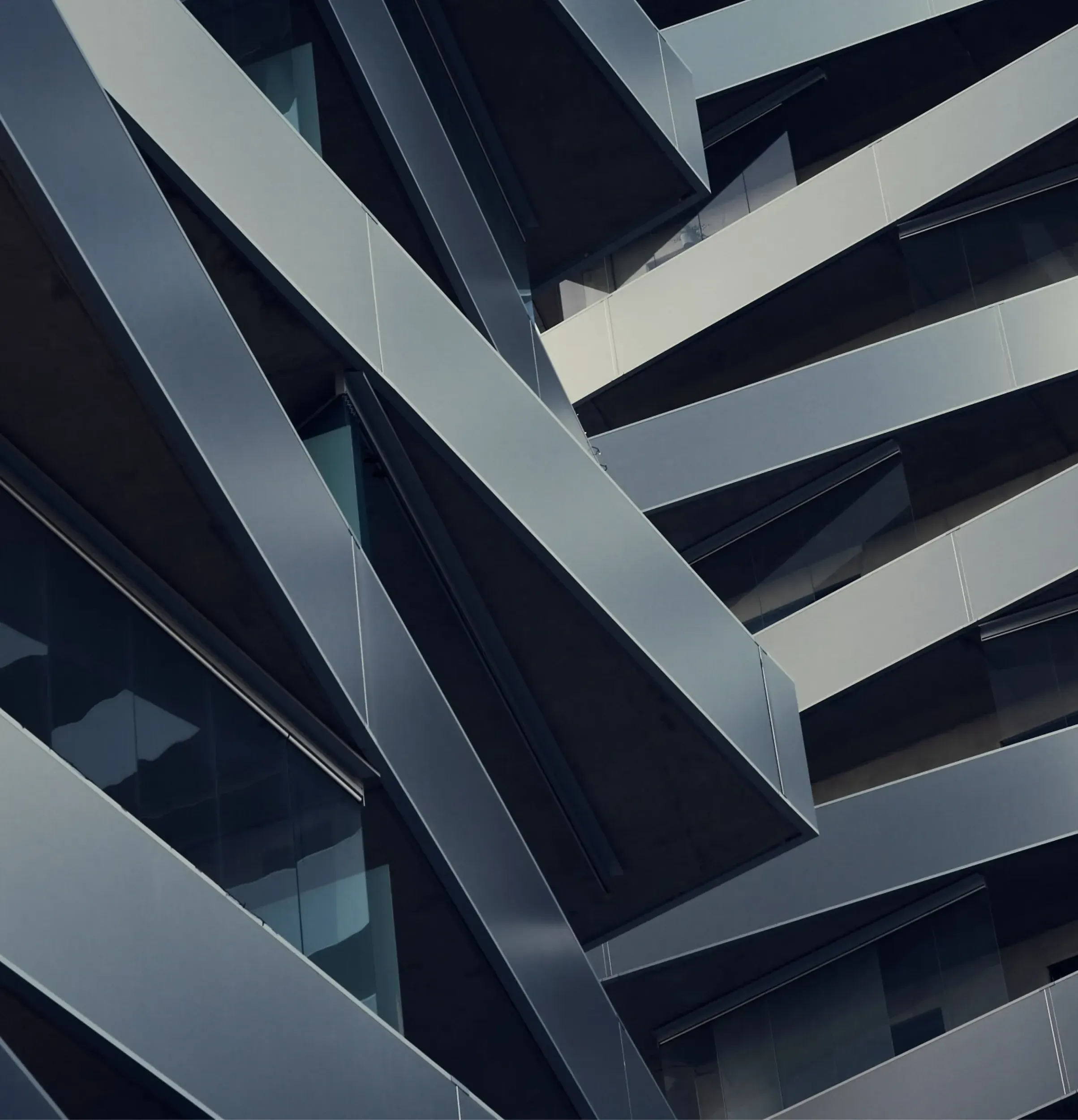 Close-up of a building facade with intersecting geometric metal beams, reflecting MS Metals' precision and the sophisticated branding by Skyne, a creative agency.