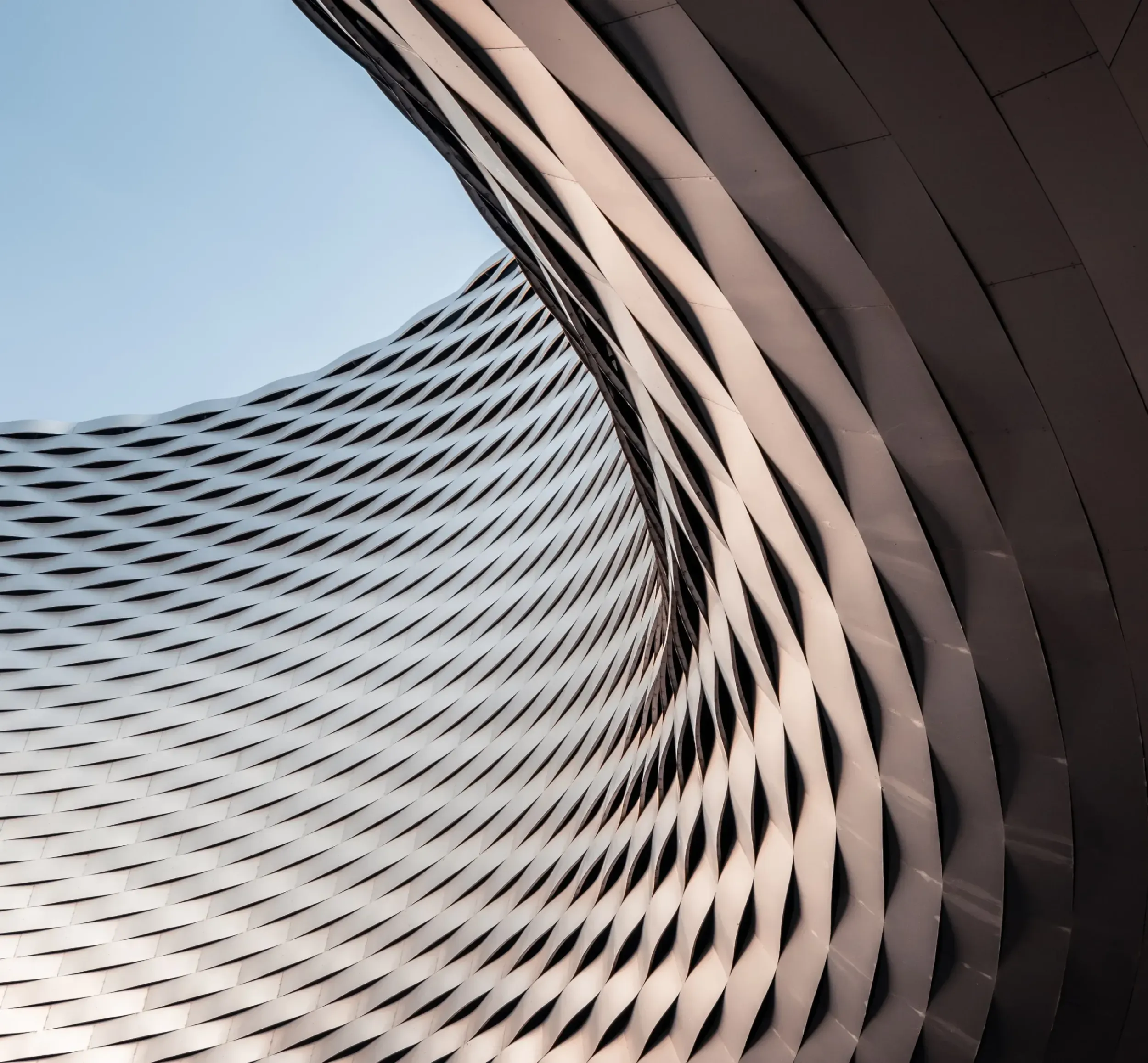Modern building facade with a complex wavy metal pattern, representing MS Metals' advanced solutions and the innovative branding by Skyne, a creative agency.