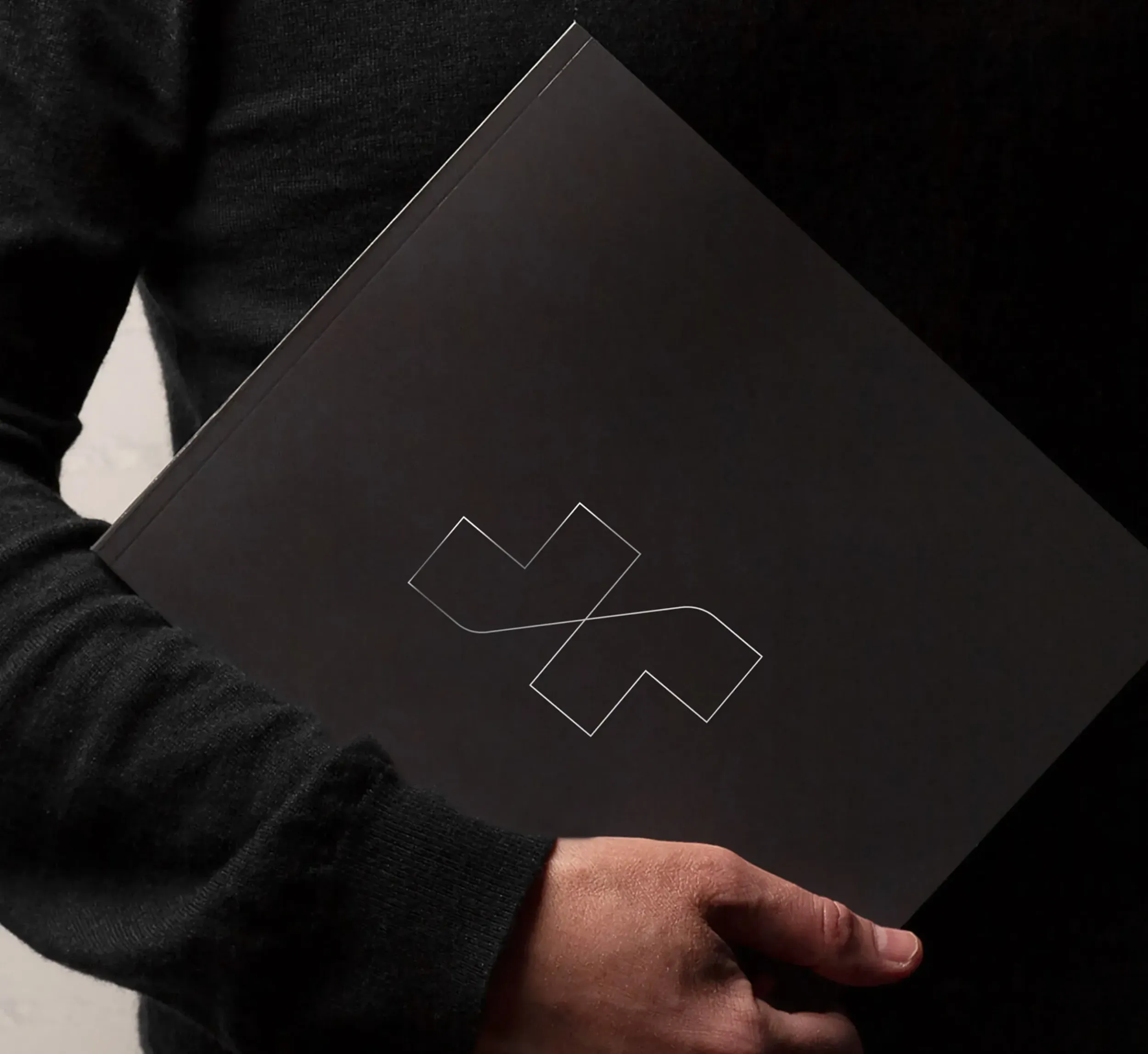 Person holding a dark gray folder with the MS Metals logo, emphasizing sleek corporate design and branding by Skyne, a branding agency.