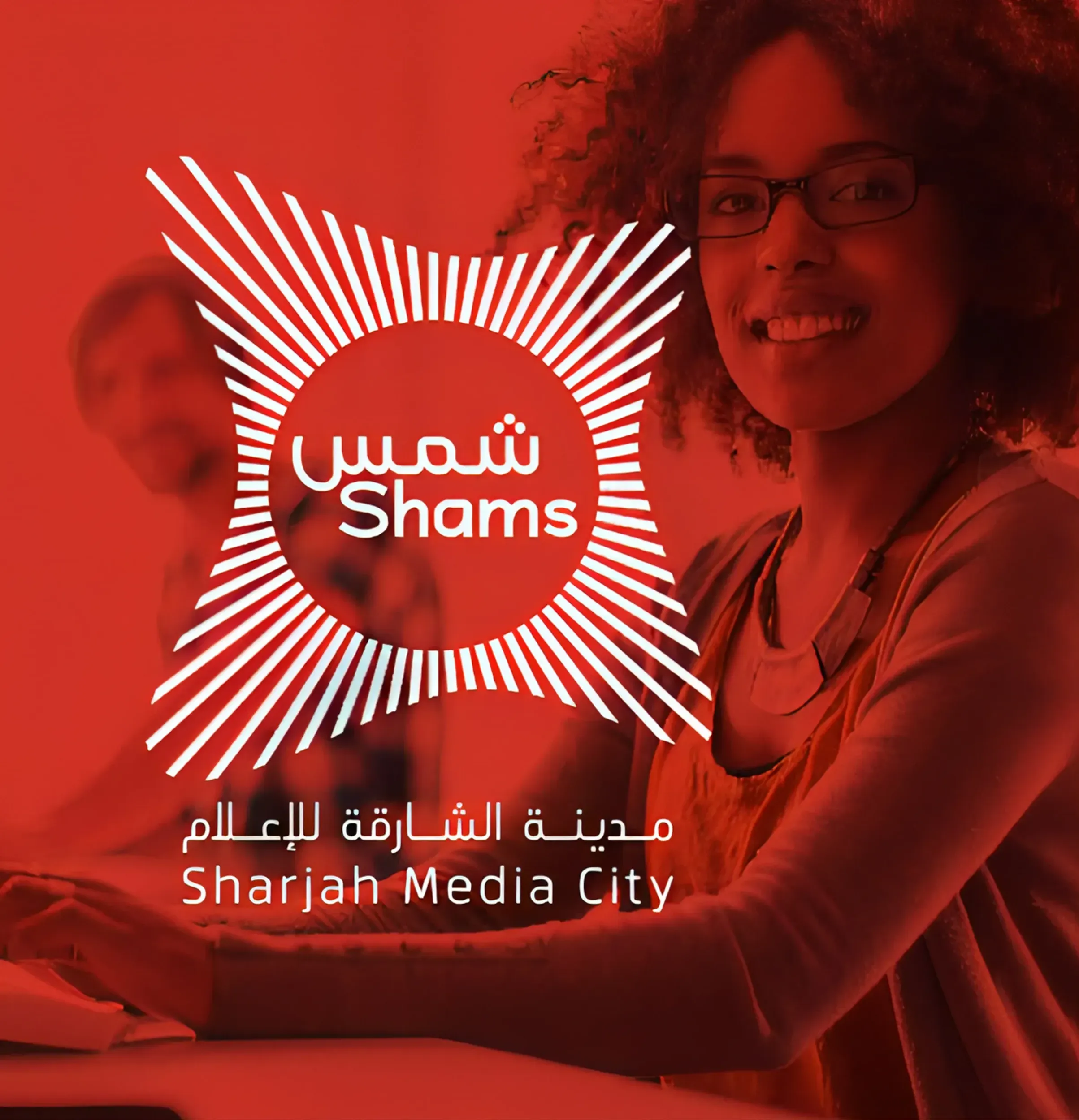 Woman smiling at a computer, with Shams Media City logo overlay. Skyne, a creative agency, positioned Shams as a hub for creative talent.