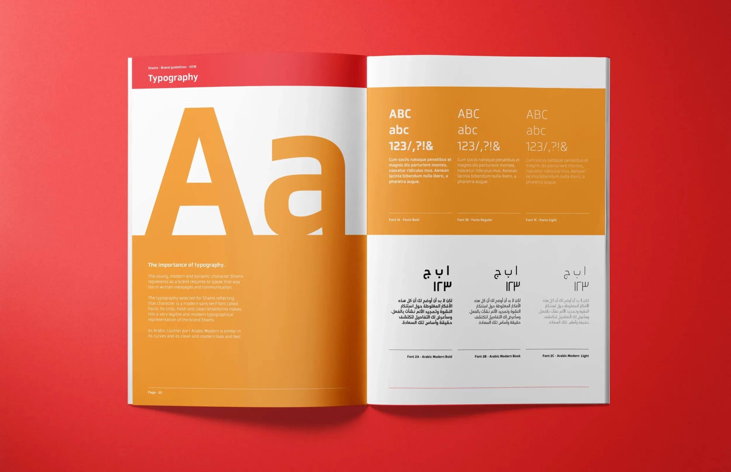 Open brand guidelines booklet on a red surface, displaying typography styles in English and Arabic with bold orange design.