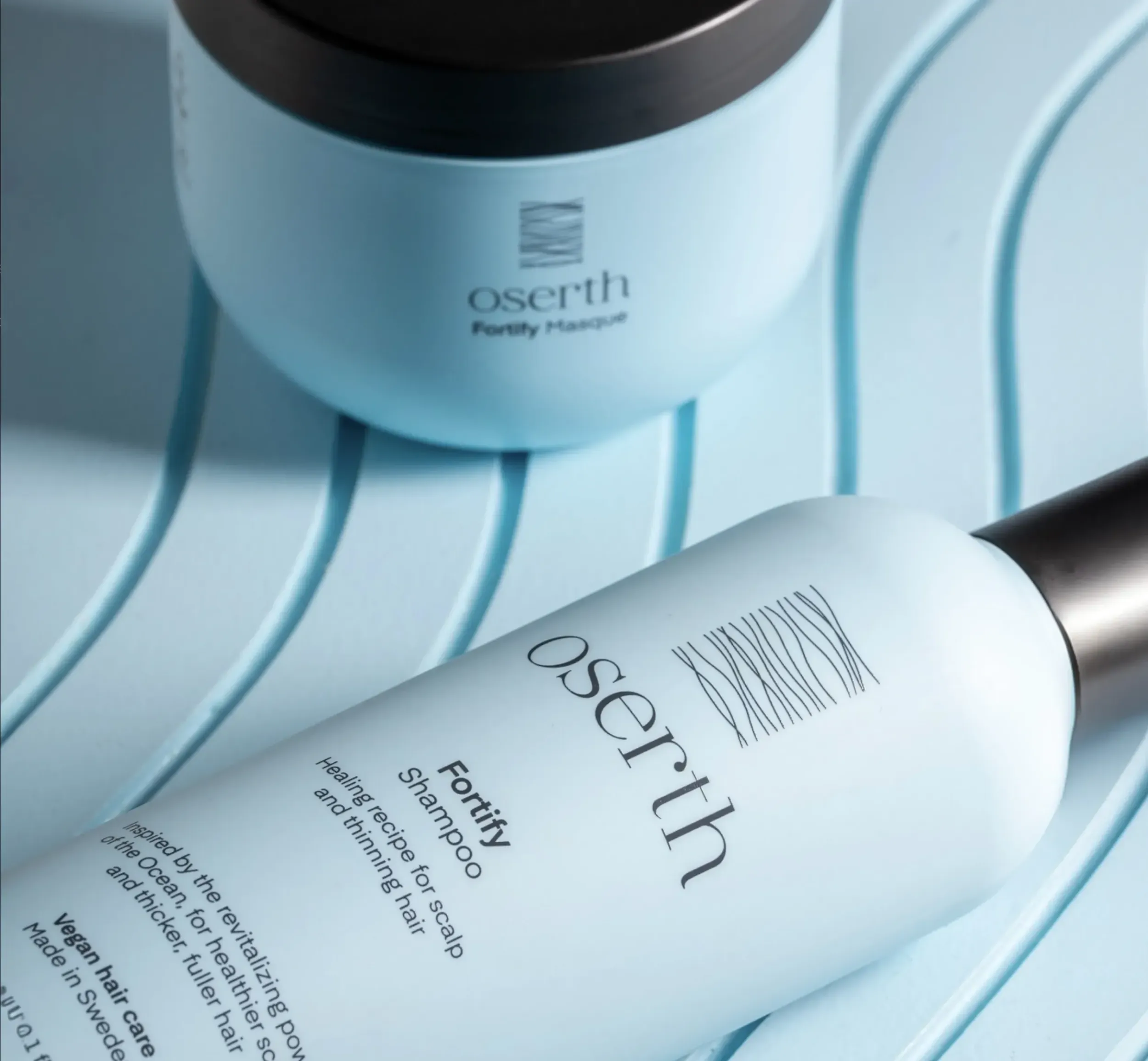 Close-up of Oserth haircare products, minimalist design, highlighting sophisticated packaging design and branding by Skyne, a creative agency specializing in packaging design.