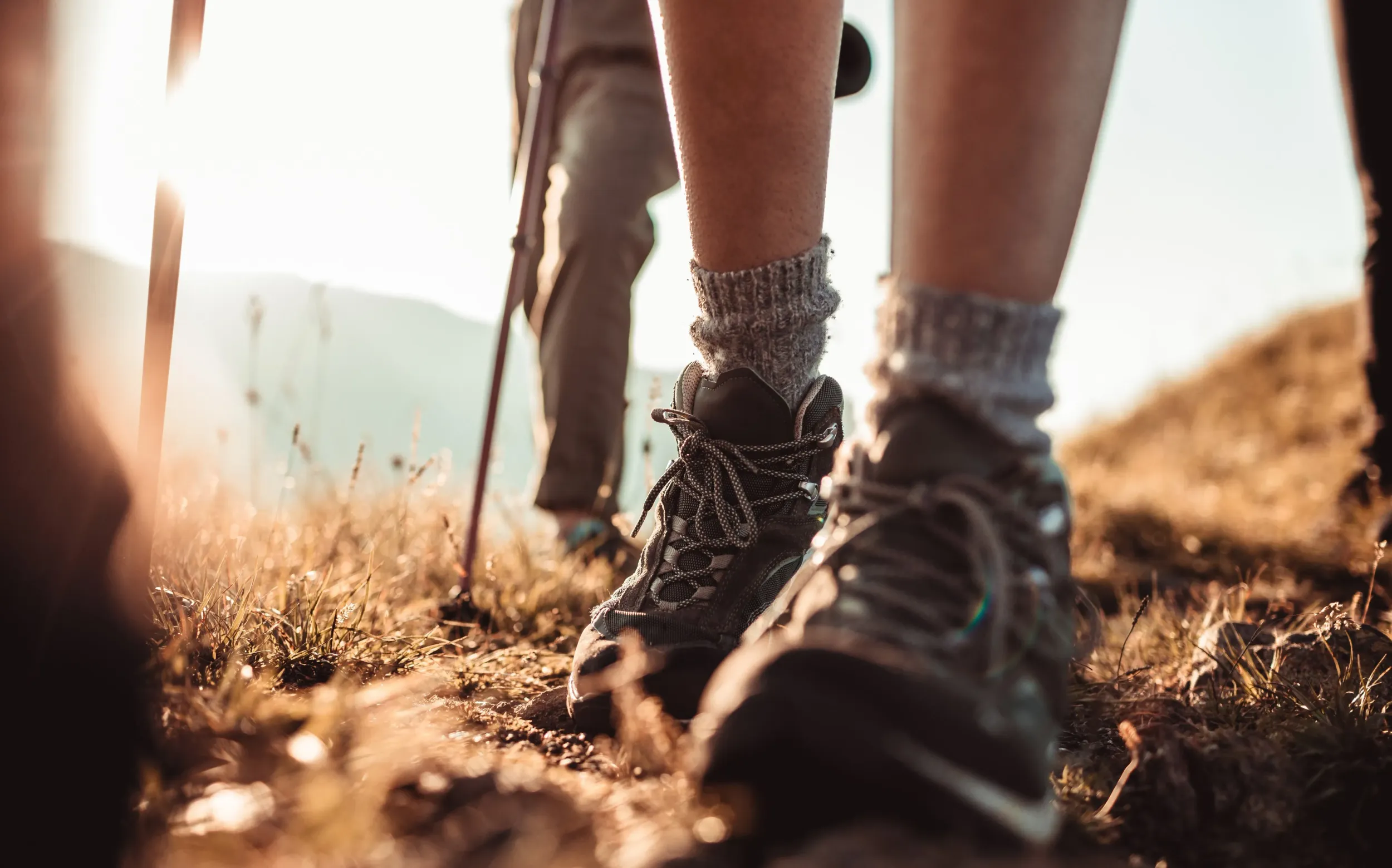 Close-up of hiking boots on a trail at sunset, evoking adventure. This represents Naseem's outdoor experiences, aligning with Skyne's branding and creative agency efforts.