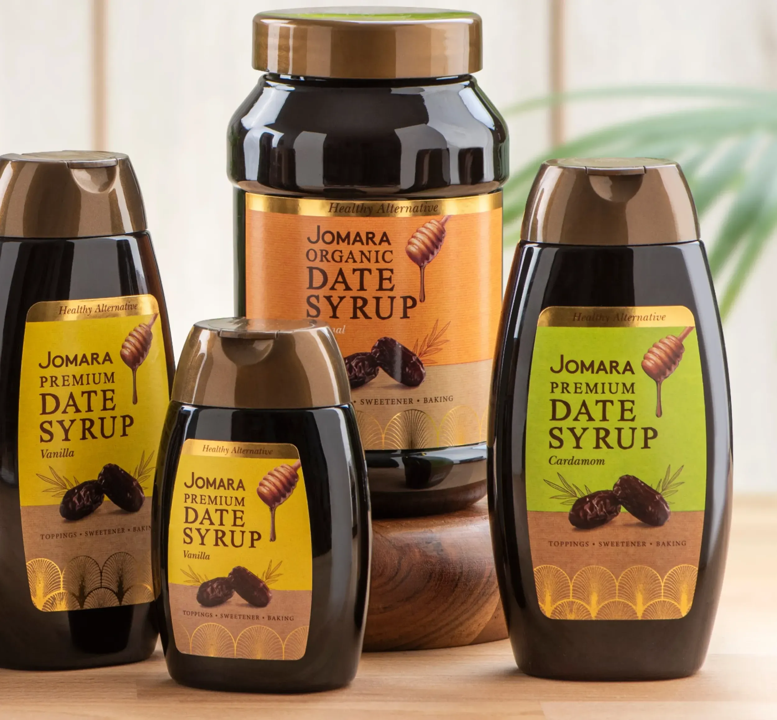 Collection of Jomara Premium Date Syrup bottles, showcasing diverse product packaging design by Skyne, a creative agency known for effective branding solutions.