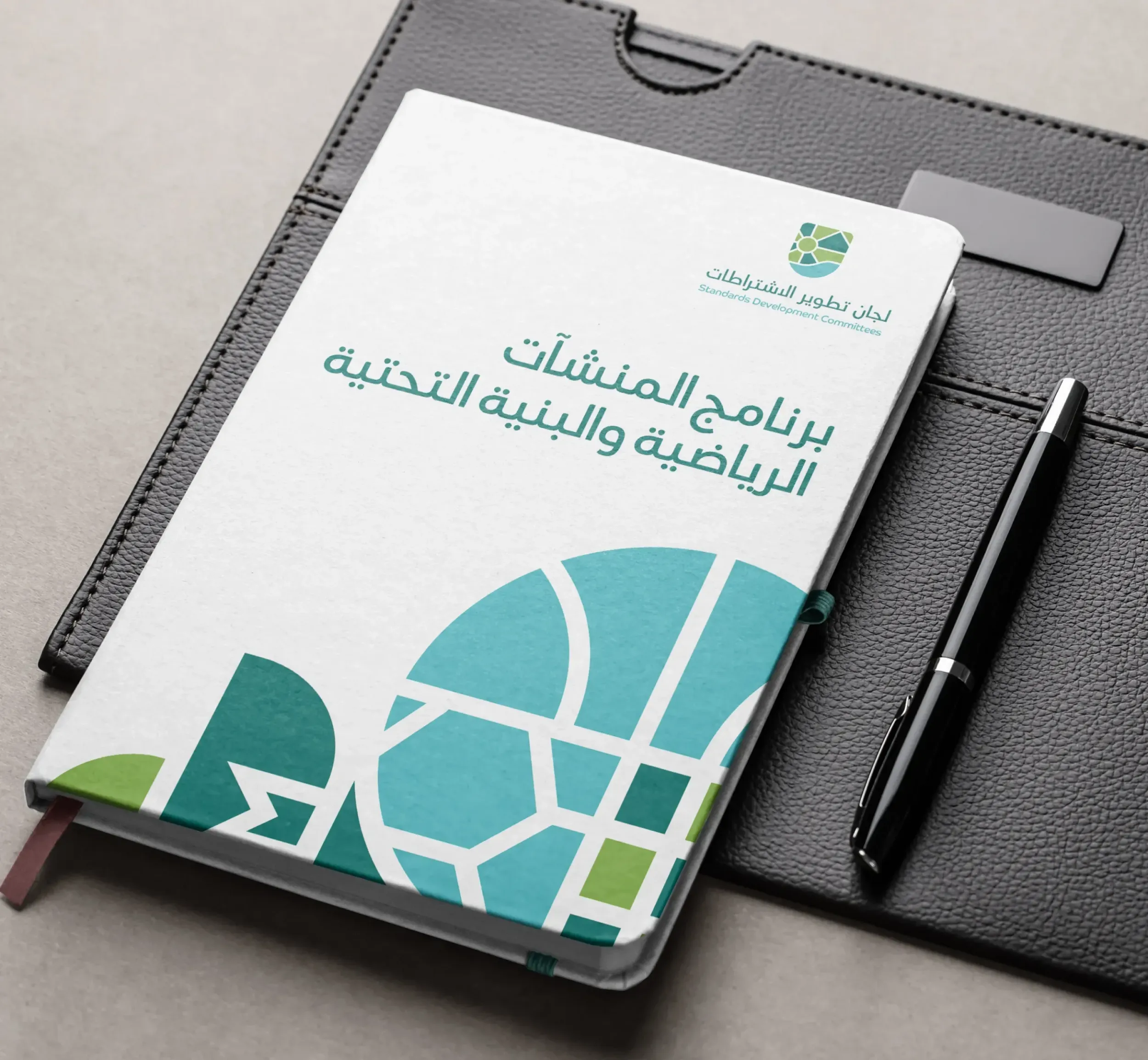 Standards Development Committees notebook with a pen, showcasing the program for sports facilities and infrastructure. Skyne, a branding agency, designed professional collateral. 