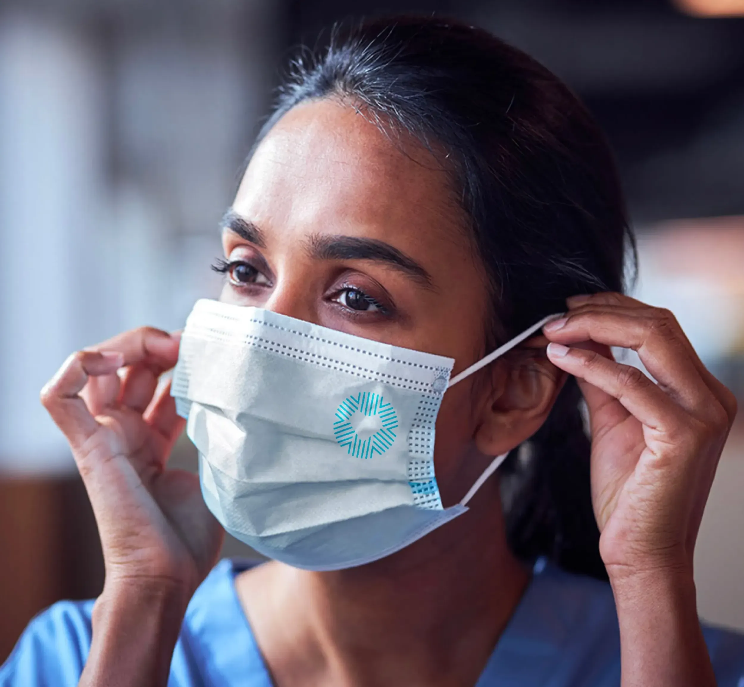 A healthcare professional adjusting a face mask with the Care Medical logo, symbolizing patient safety and care, a key message reinforced by Skyne's branding agency expertise.