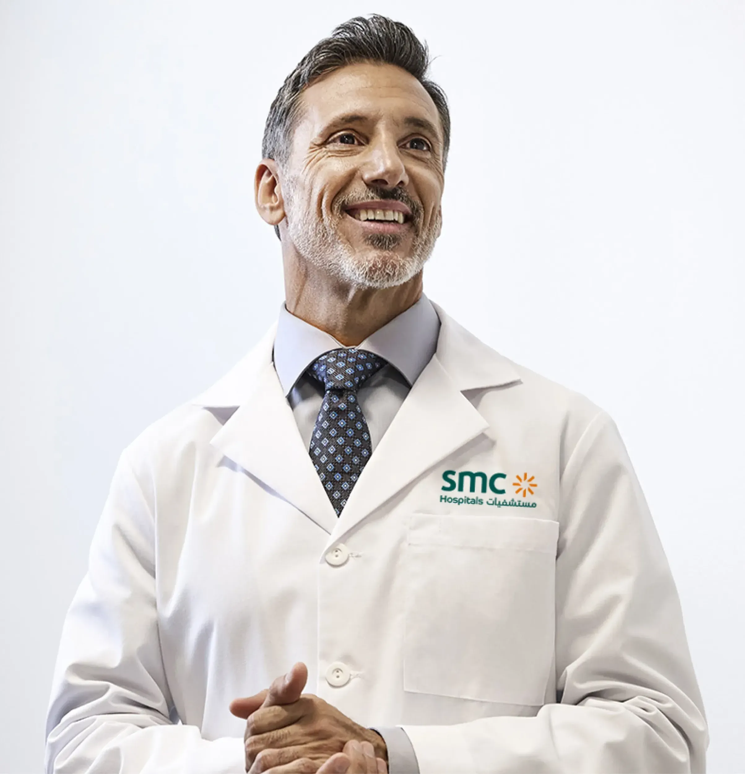 Smiling doctor in SMC Hospitals branded uniform, representing the human-centered approach of Skyne's healthcare branding and hospital marketing.