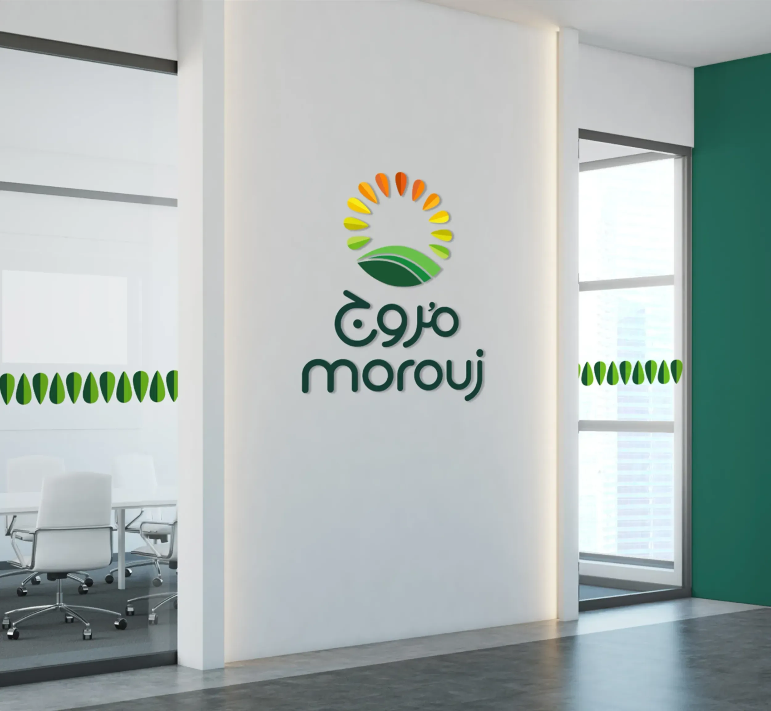 Office interior featuring the Morouj logo on a white wall, with Arabic and English text below a sun and green field emblem