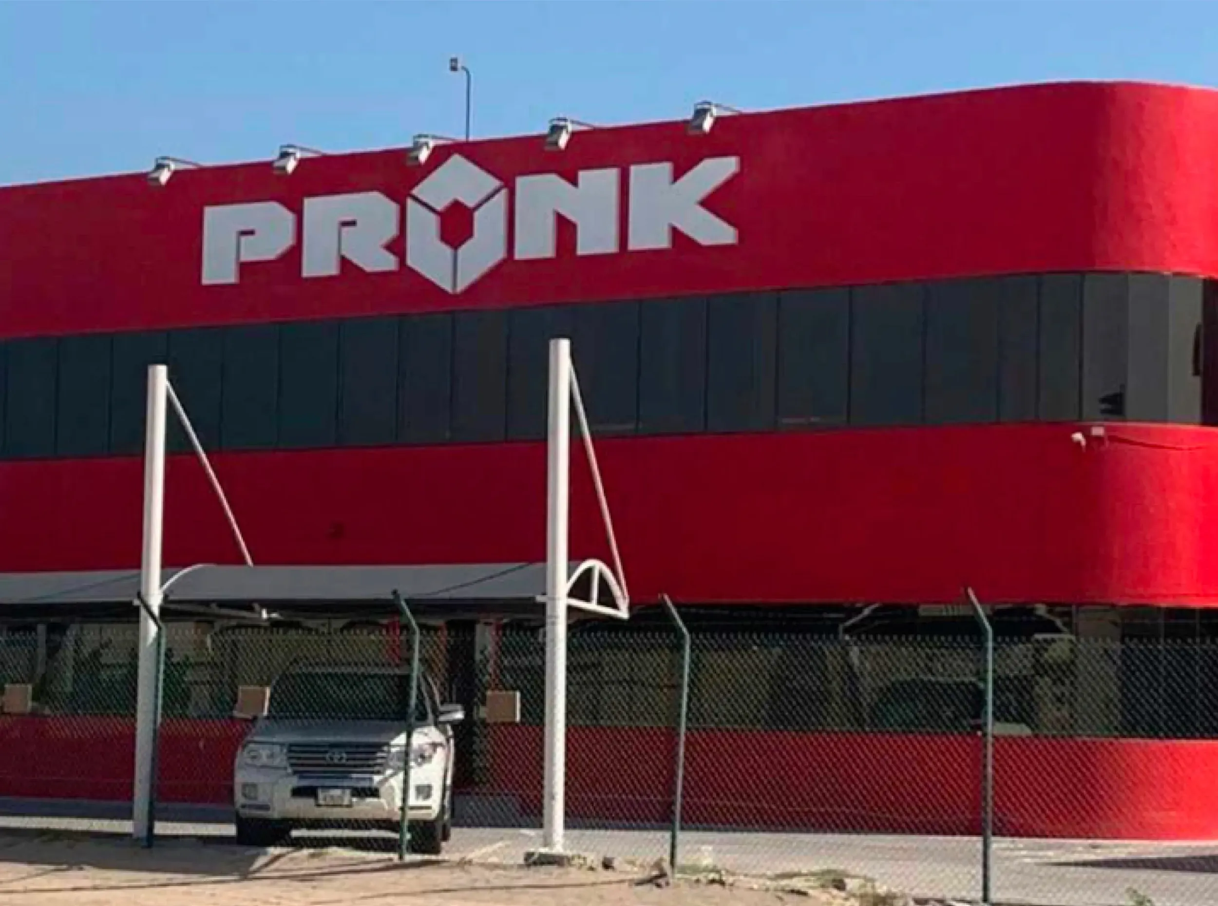 Exterior of Pronk headquarters with bold red and black facade featuring large logo, architectural branding by Skyne branding agency