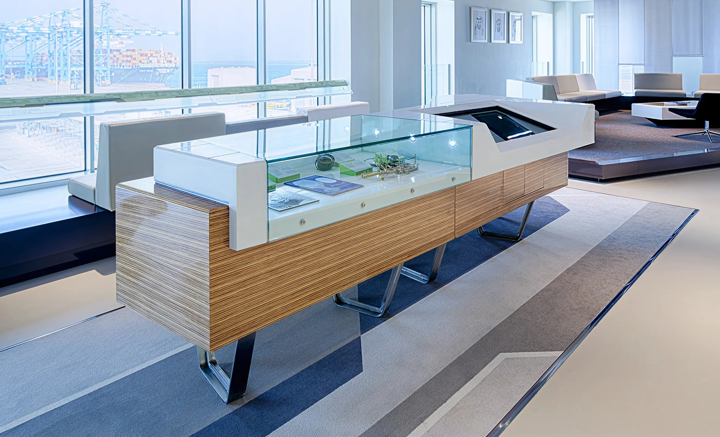 Modern interactive display table with touchscreen and scale model, located inside Khalifa Port Visitor Centre.