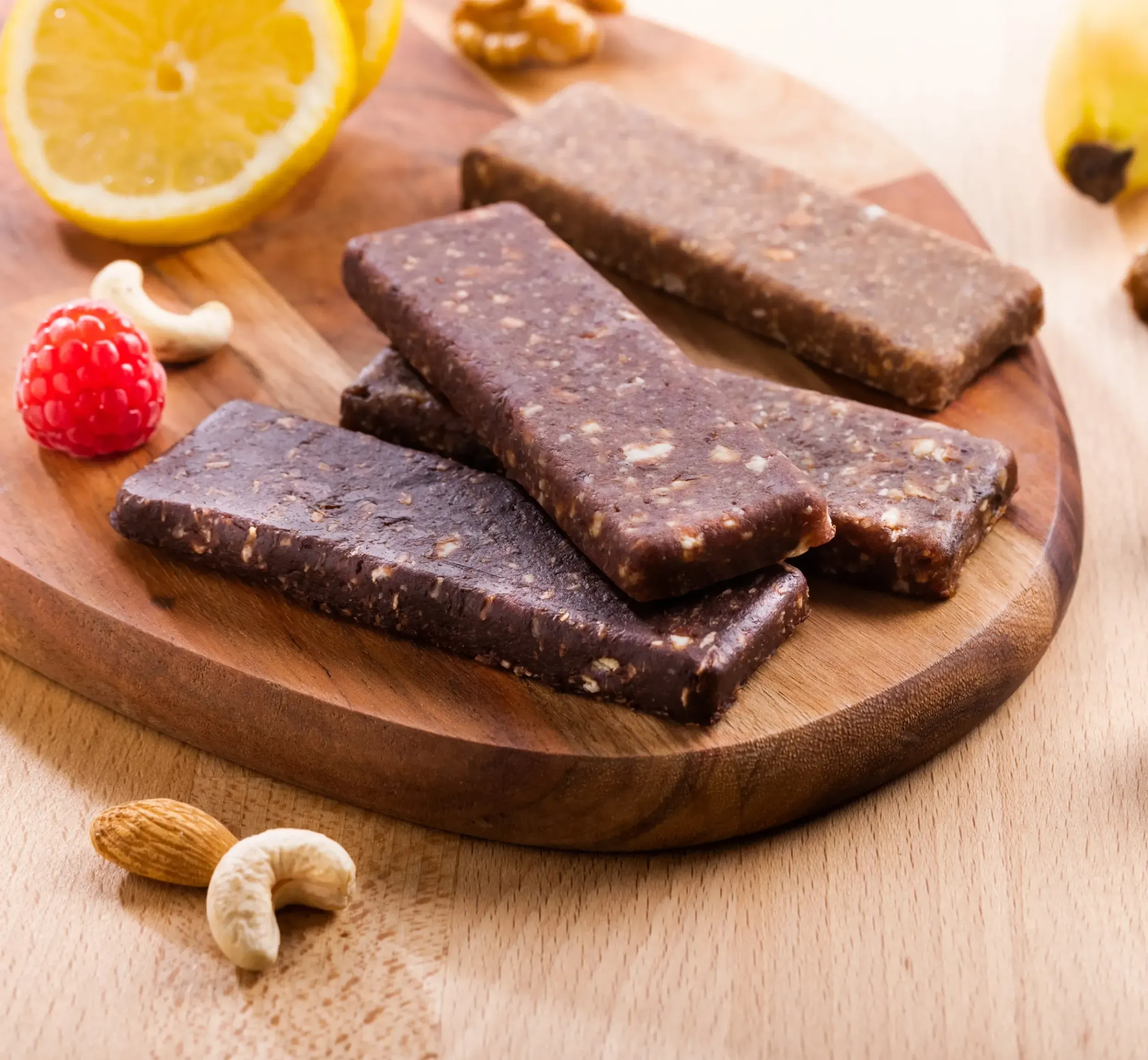 Organic date bars with nuts and fruits on wooden board