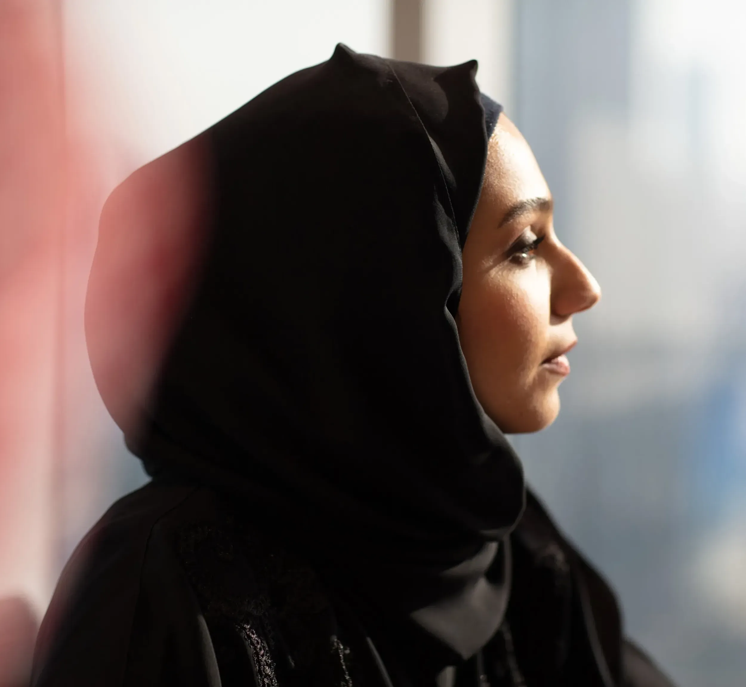 A thoughtful woman in traditional attire, representing the Basamh Group's commitment to local talent and heritage. Skyne, a creative agency, helps brands connect with their audience. 