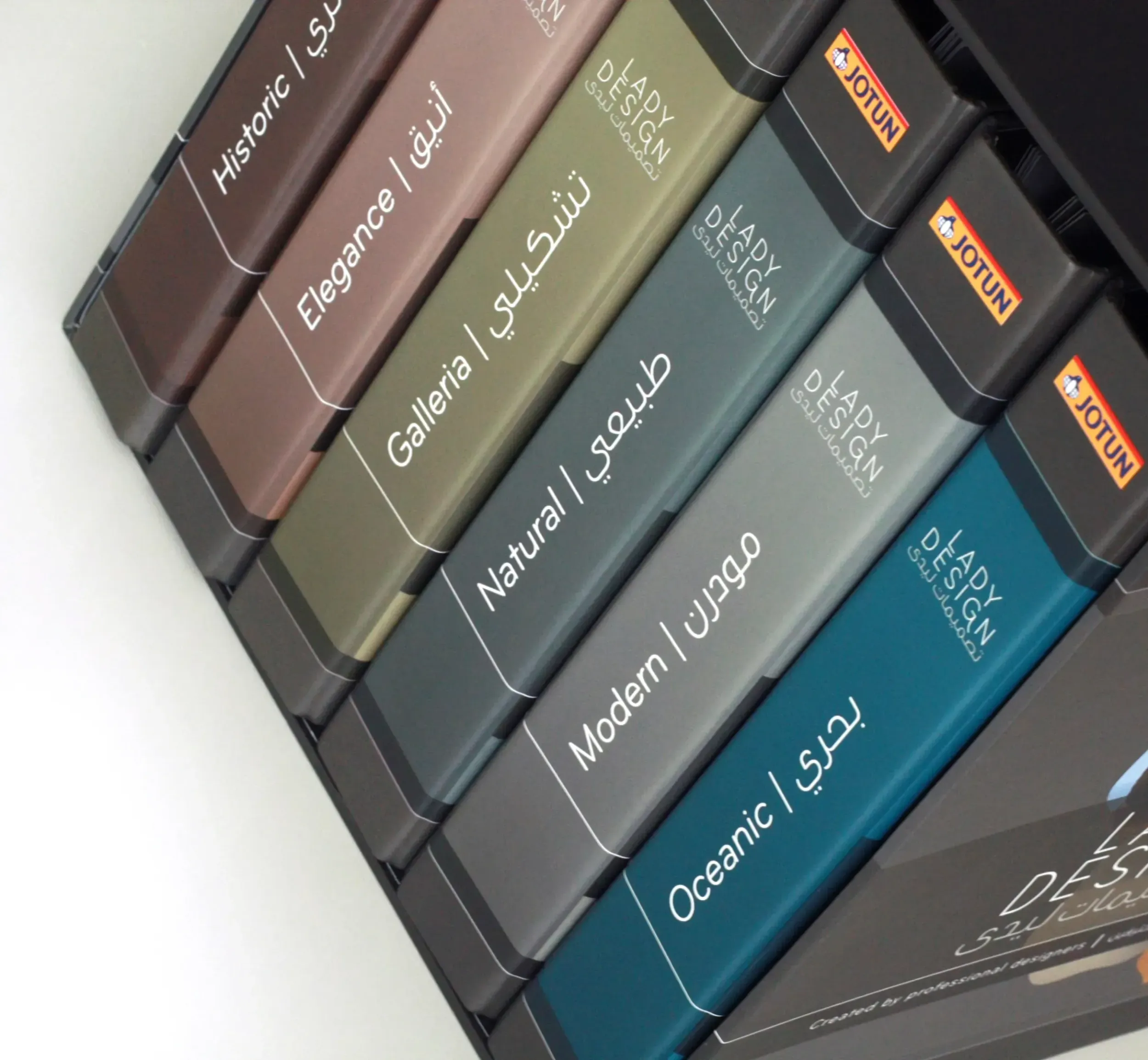 Jotun Lady Design color folders labeled with themes like Historic, Natural, and Oceanic, featuring bilingual English-Arabic text.