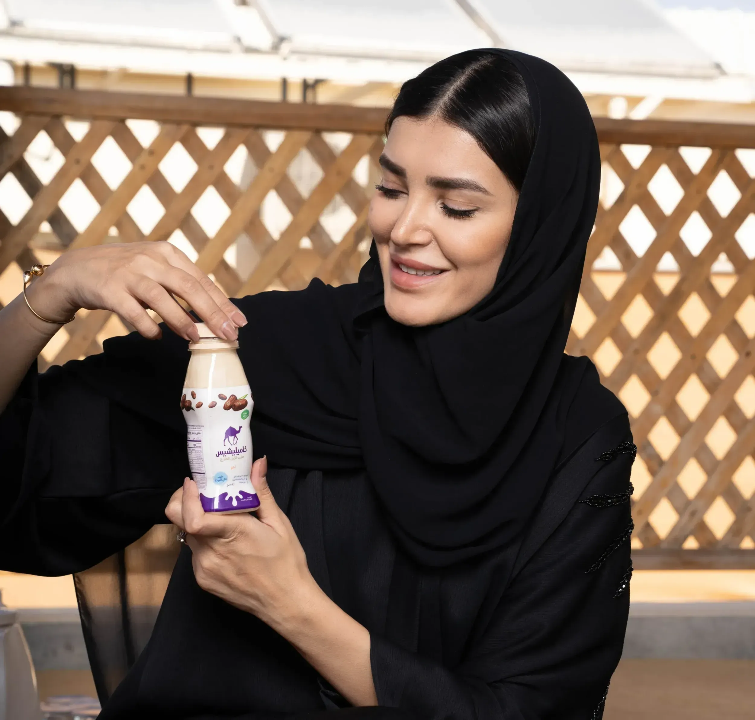 A woman holding a Camelicious camel milk bottle, emphasizing the product's appeal to modern consumers and Skyne's focus on people-centric branding for FMCG products.