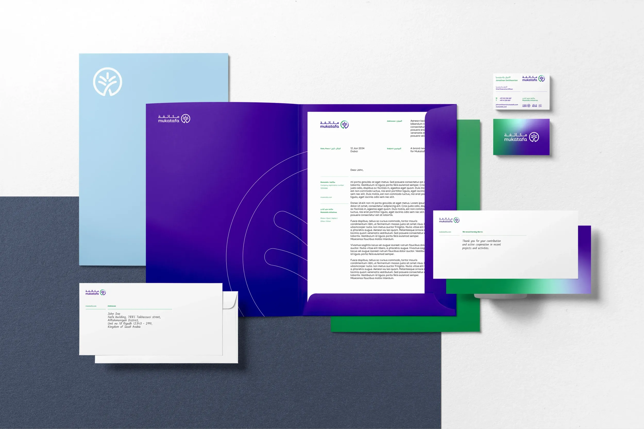 Mukatafa branded stationery set including folder, letterhead, business cards, and envelopes in blue, purple, and green tones.