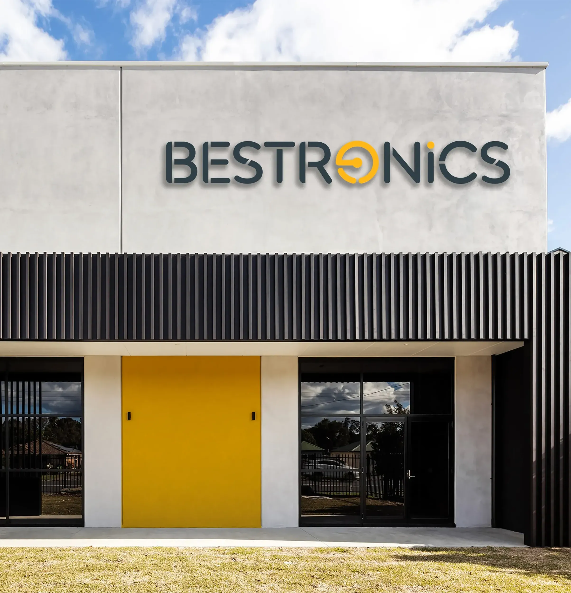 Bestronics logo on a modern building with a yellow door, showcasing physical application of new branding and comprehensive branding solutions by Skyne, a branding agency.