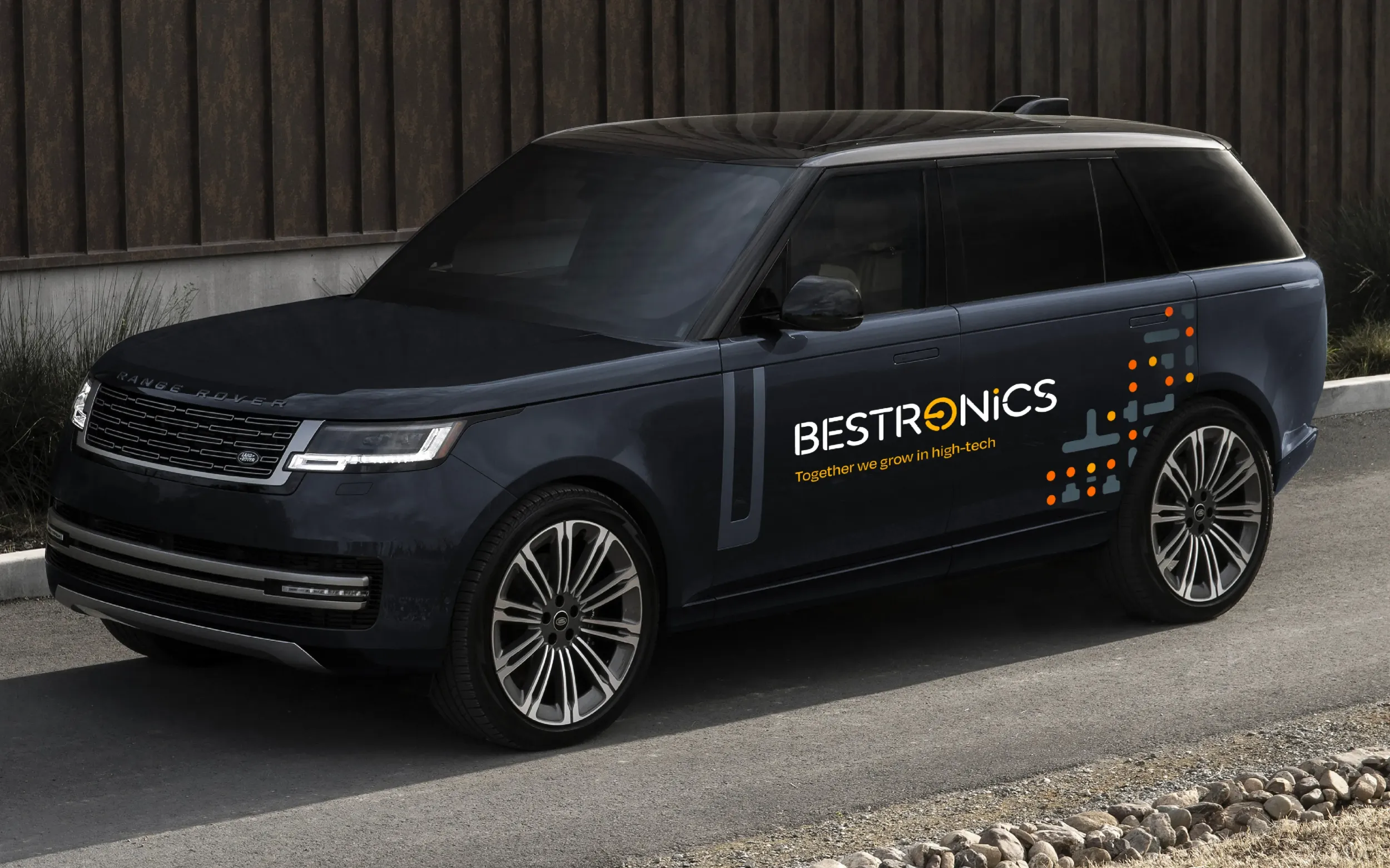 Dark grey Range Rover with Bestronics branding on the side, illustrating brand’s presence in corporate mobility and comprehensive branding by Skyne, a creative agency.