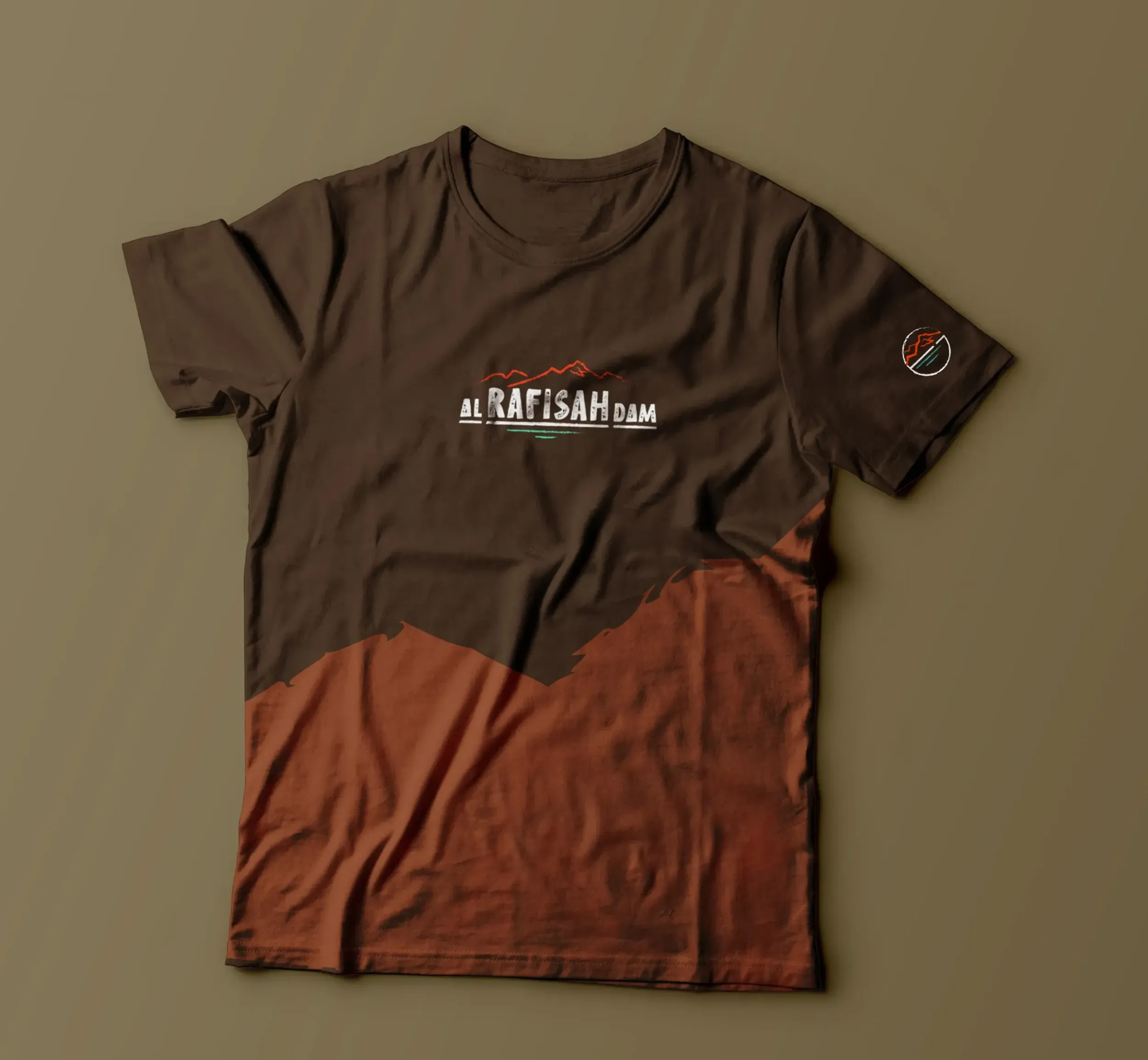 A branded t-shirt for Al Rafisah Dam, featuring the logo and a design inspired by the Hajjar mountains. This merchandise, a result of Skyne's branding work, helps promote the destination's identity.