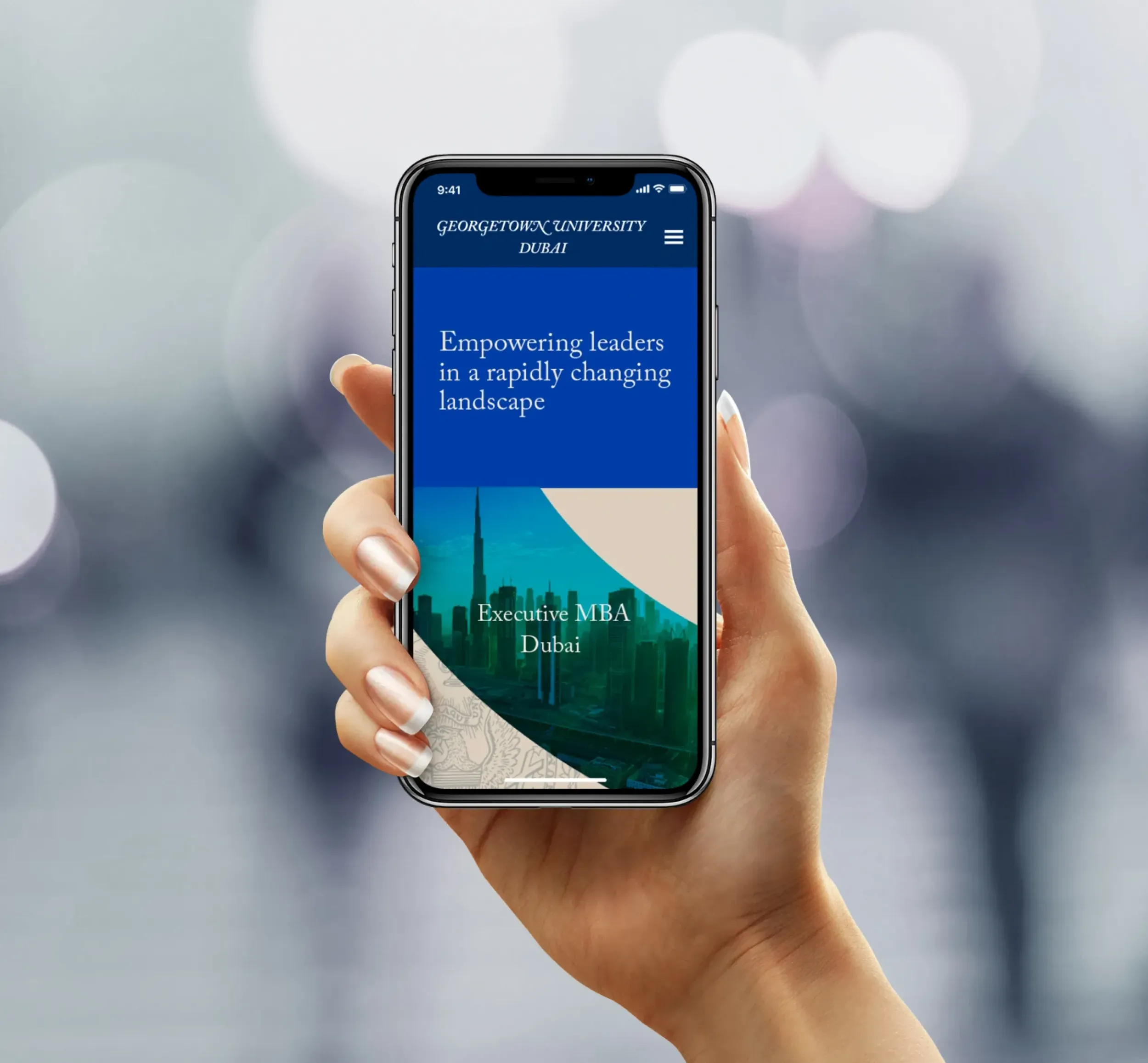 Hand holding a smartphone displaying the Georgetown University Dubai website with Dubai skyline. Skyne excels in web design and digital branding for educational institutions in Dubai, Riyadh, and Jeddah.