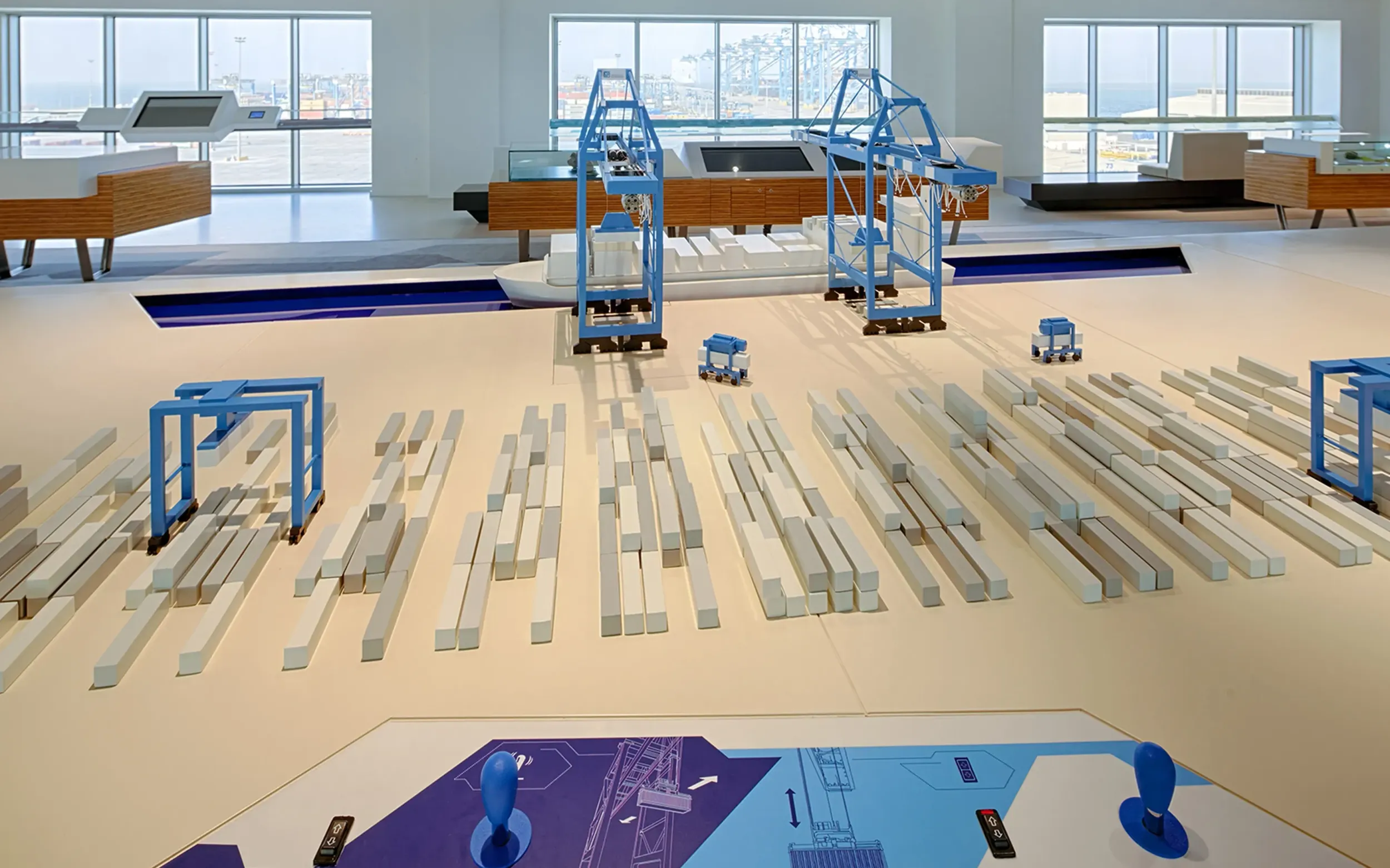 Interactive scale model of Khalifa Port Container Terminal with blue cranes and container stacks inside the visitor centre.